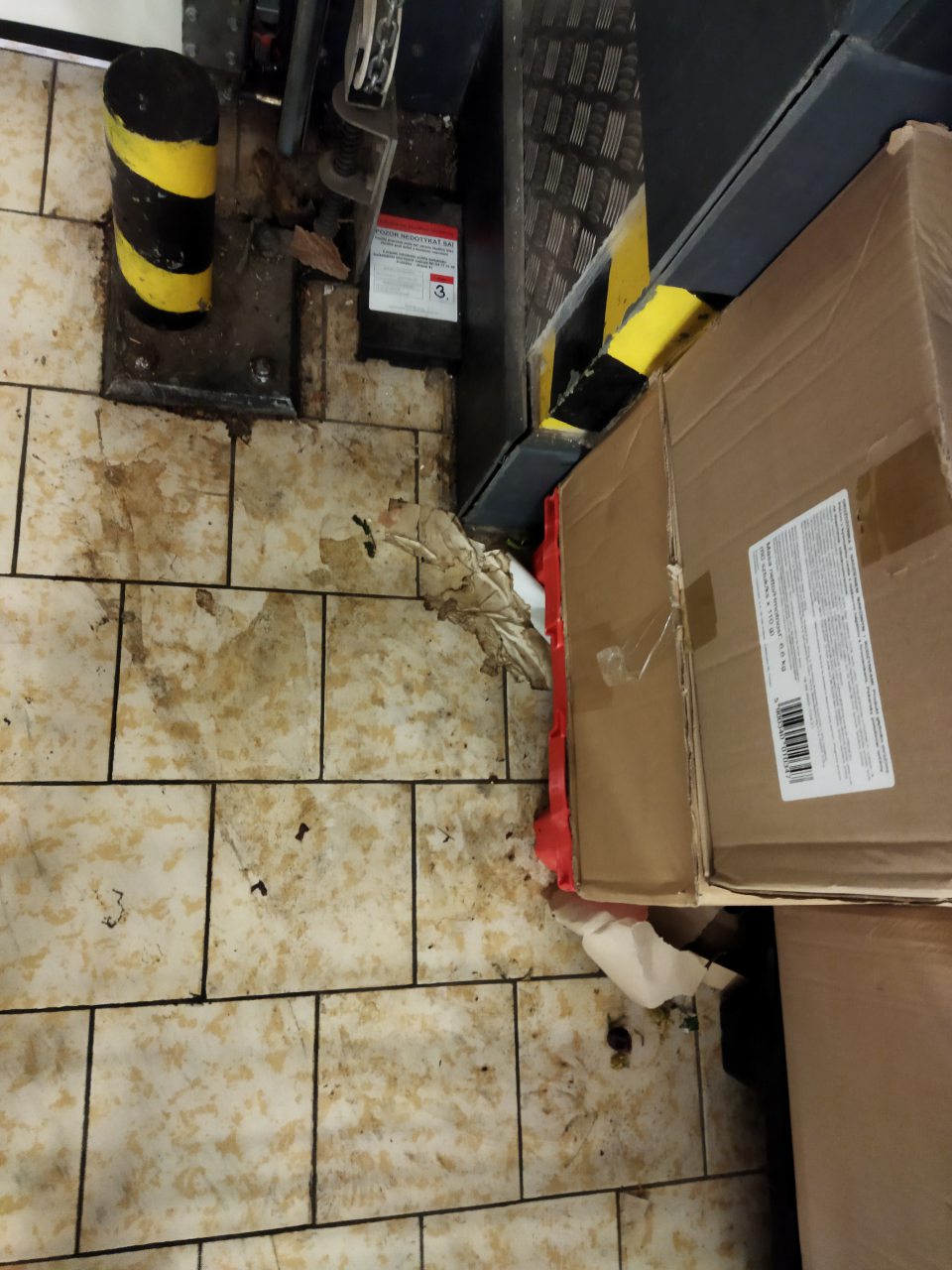 Zanedbaná hygiena podláh v sklade prevádzky v ťažšie dostupných častiach pri príjmových bránach do prevádzky