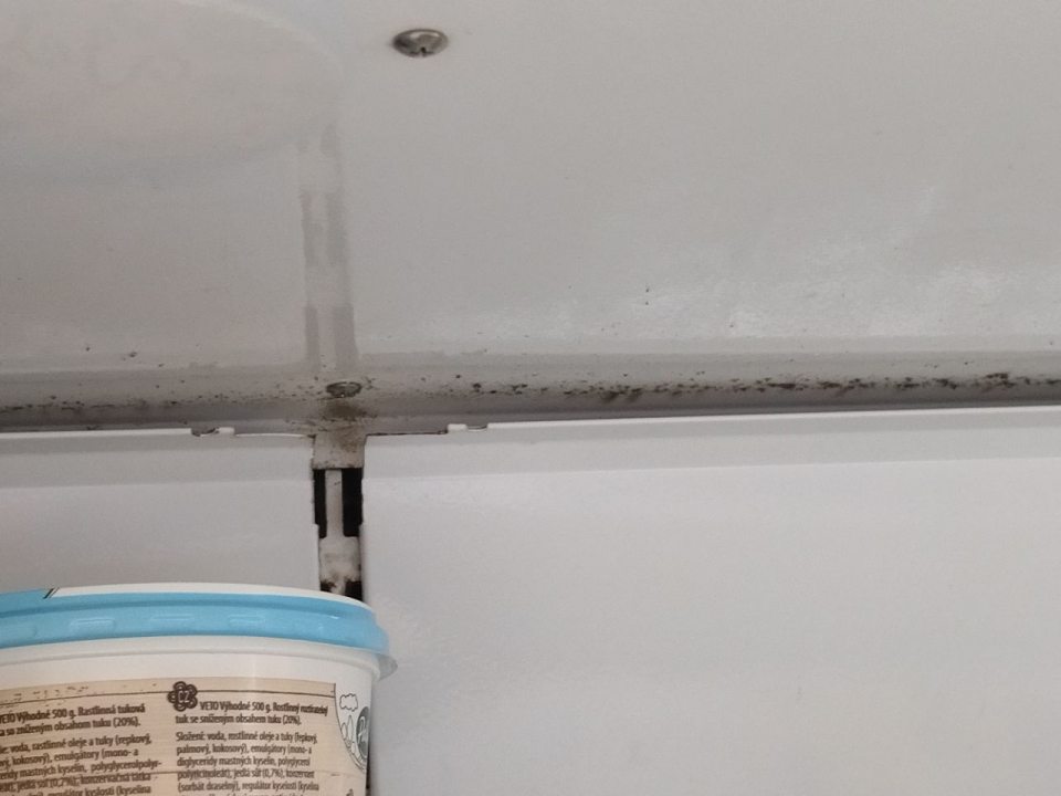 Znečistená chladiaca vitrína na predajnej ploche.