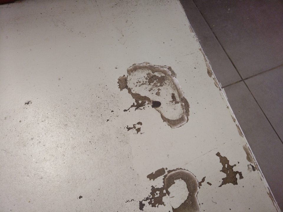 Poškodená podlaha v skladovacích priestoroch prevádzky.