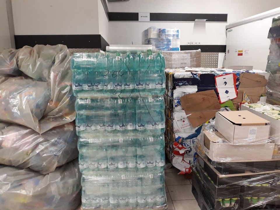 Vrece s fľašami z fľaškomatu v časti s označením ,, pre uskladnenie pečiva,, vedľa na palete fľaše s nealko nápojmi a tiež paleta s uloženými potravinami ( kartónové krabice, v ktorých boli umiestnené trvanlivé mäsové výrobky a vajcia)