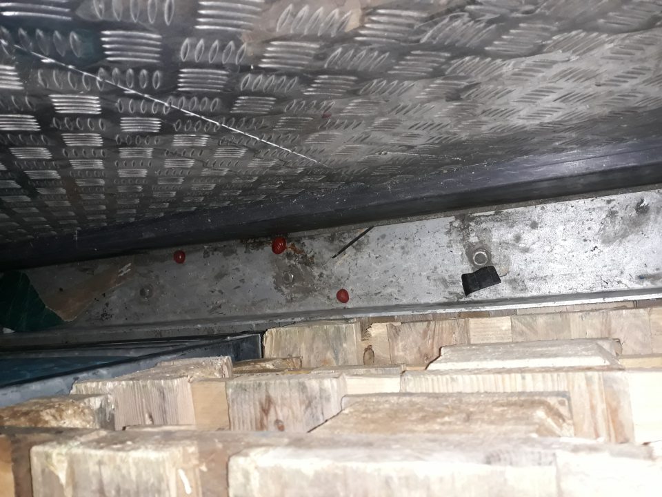 Znečistená podlaha v skladovom priestore pri príjmovej rampe za paletami.