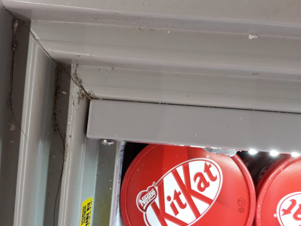 Priestor v rohu pod vodiacou lištou mraziaceho zariadenia slúžiaceho na vystavovanie a predaj mrazených krémov je silne znečistený zaschnutou špinou. 