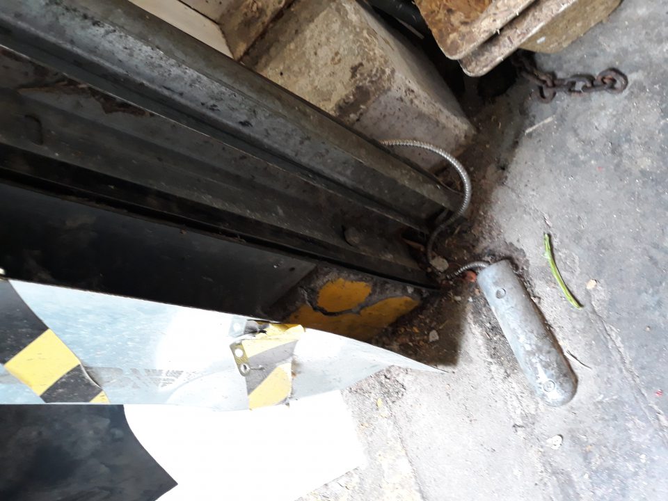 Pri príjmovej rampe na pravej strane v rohu zdvíhacích dverí silne znečistená podlaha napadanými mechanickými nečistotami a plechová lišta nedolieha na bočnú stranu príjmovej rampy.