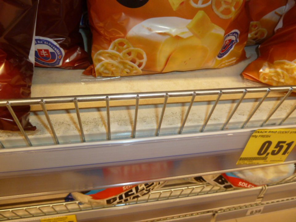 Na regáloch vrstva usadenej špiny  a zvyšky nečistôt v blízkosti kovovej konštrukcie.