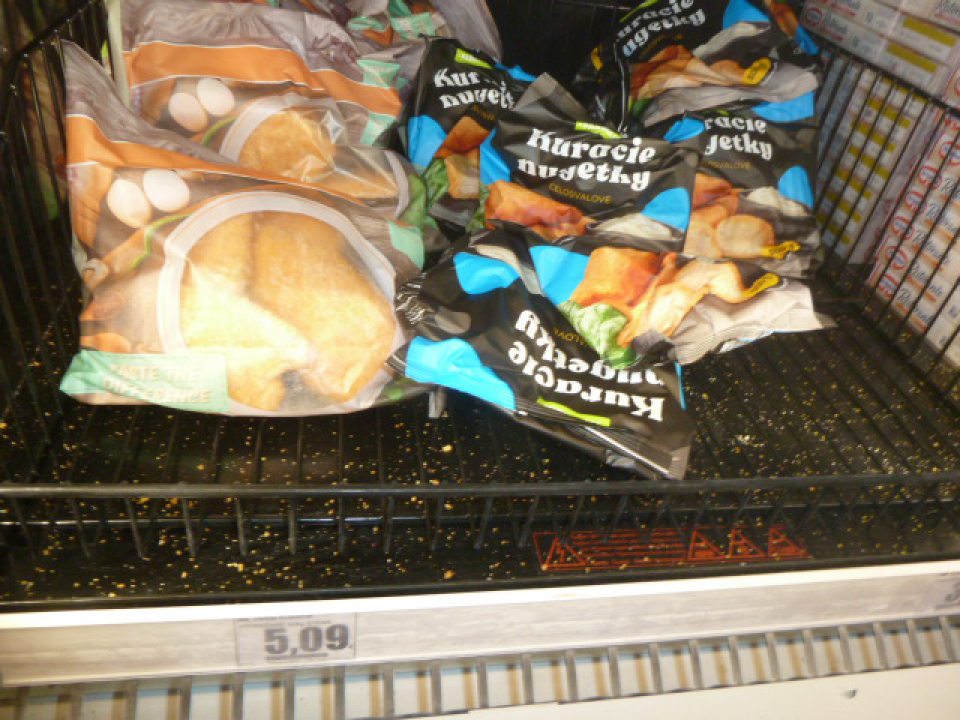 V mraziacej vitríne pre uskladnenie hlbokozmrazených polotovarov  roztrúsené zvyšky  z predávaného sortimentu potravín.