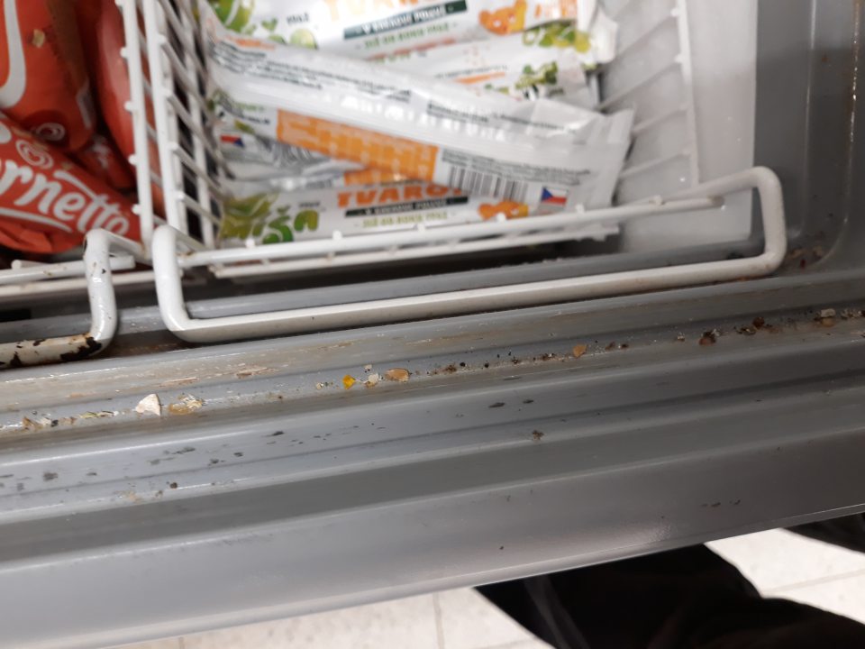 Na predajnej ploche vodiace lišty v mraziacom zariadení s nadpisom ,,Algida,, slúžiacom na vystavovanie a predaj mrazených krémov silne znečistené prachom, nečistotami, zaschnutou špinou a mechanickými nečistotami, taktiež povrch koša narušený s výskytom korózie.