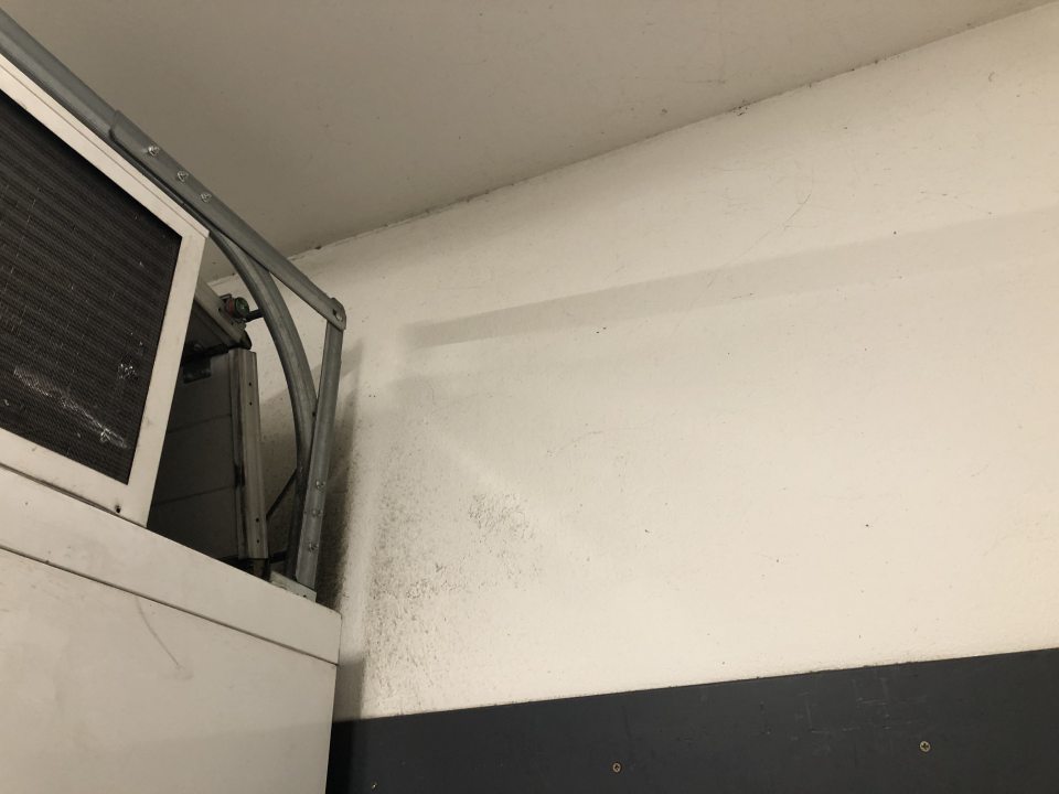 Zázemie predajne - znečistená stena nad chladiacim boxom.