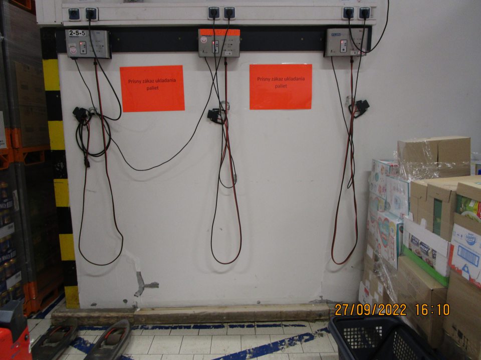 v zázemí v časti označenej ak prísny zákaz ukladania paliet opadaná a opukaná omietka a odkrytá až do časti zo spodnou stierkou v rozsahu cca 20cmx20cm