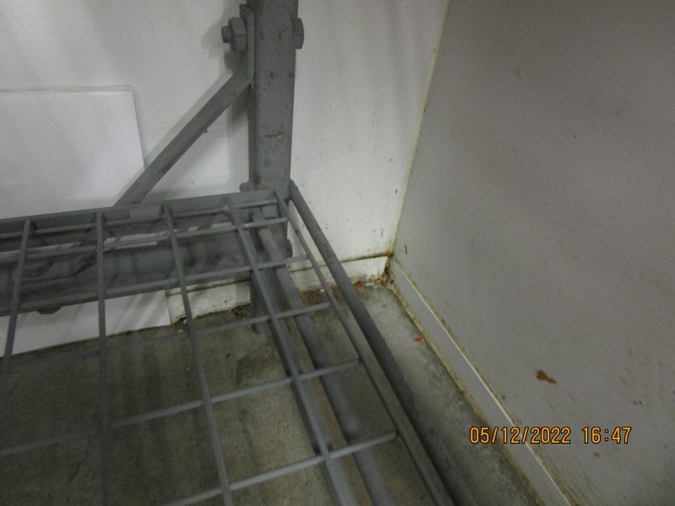 v zázemí prevádzky v chladiacom boxe s uskladnenými mliečnymi a mäsovými výrobkami značne znečistená podlaha vyliatou tekutinoun a v pravom rohu nános špiny a nečistôt