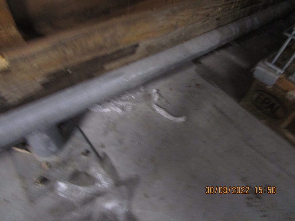 pri paletách s kovovými mriežkami znečistená podlaha kúskami plastov, nános prachu a špiny