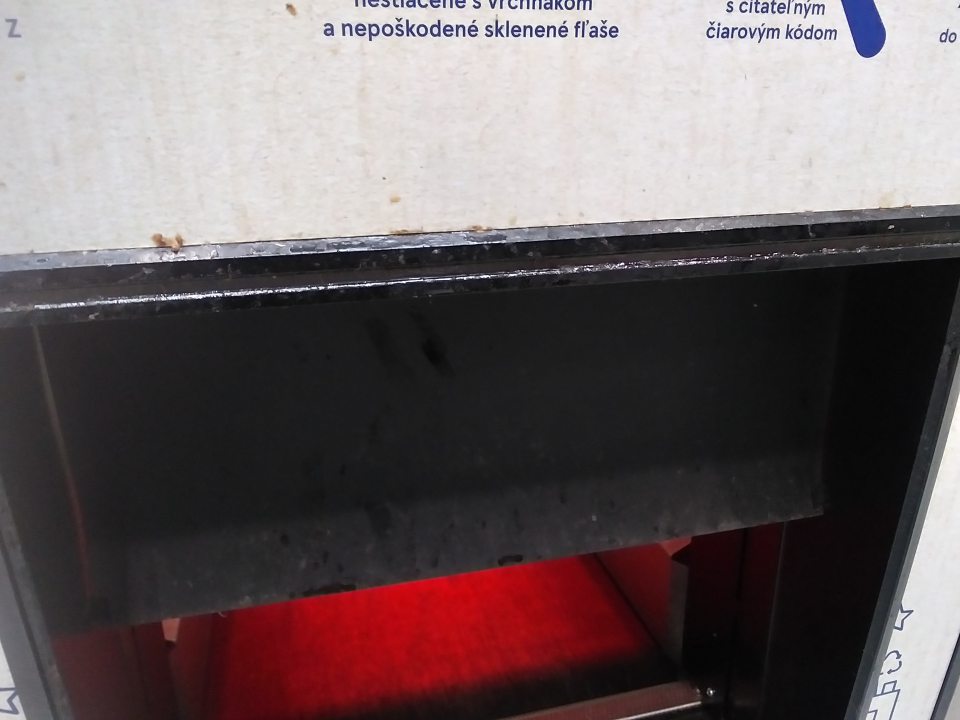 nálepy, nečistoty, zvyšky tekutého obsahu fliaš v okolí dolného otvoru automatu