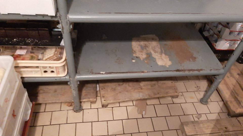 4. Poškodený náter kovových regálov so začínajúcou koróziou na viacerých miestach v chladiacom boxe na skladovanie mliečnych výrobkov.