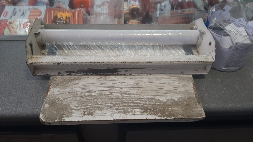 Doska s potravinovou fóliou na balenie mäsových výrobkov bola doškriabaná, náter bol olúpaný a na niektorých miestach držiaka fólie sa nachádzala hrdza.