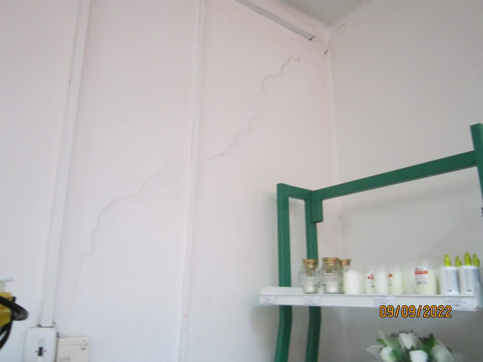 1. Popraskaná stena s opadávajúcou omietkou v predajni.