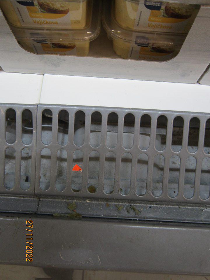 2. Znečistená ložná plocha chladiacej vitríny na predajnej ploche v časti pod mriežkou - znečistená prachom, zbytkami potravín a rôznymi nečistotami na viacerých miestach. 