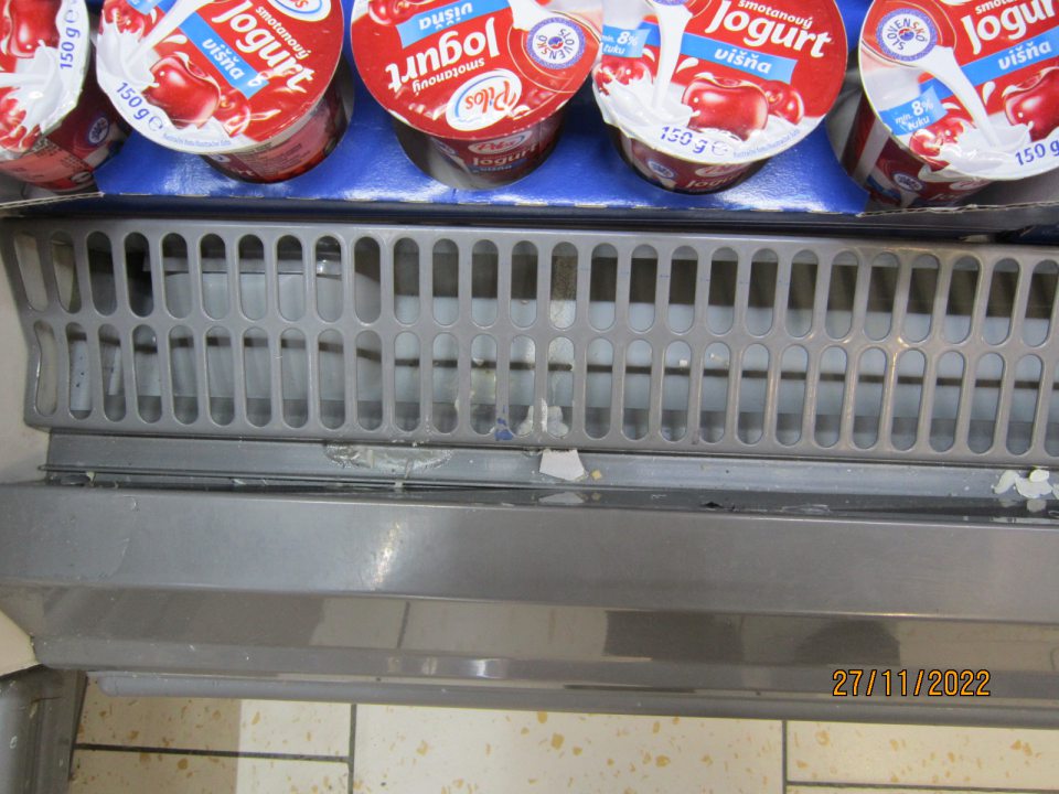 4. Znečistená chladiaca vitrína zbytkami potravín na predajnej ploche.