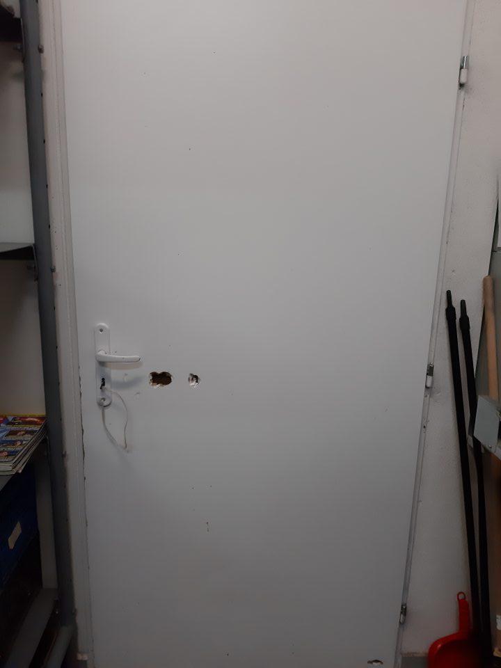 Poškodené dvere v suchom sklade potravín.