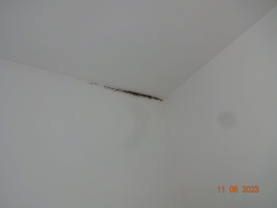  Na chodbe pred vstupom do suchého skladu znečistené steny čiernou špinou a v horných rohoch čierna špina, pravdepodobne pleseň.