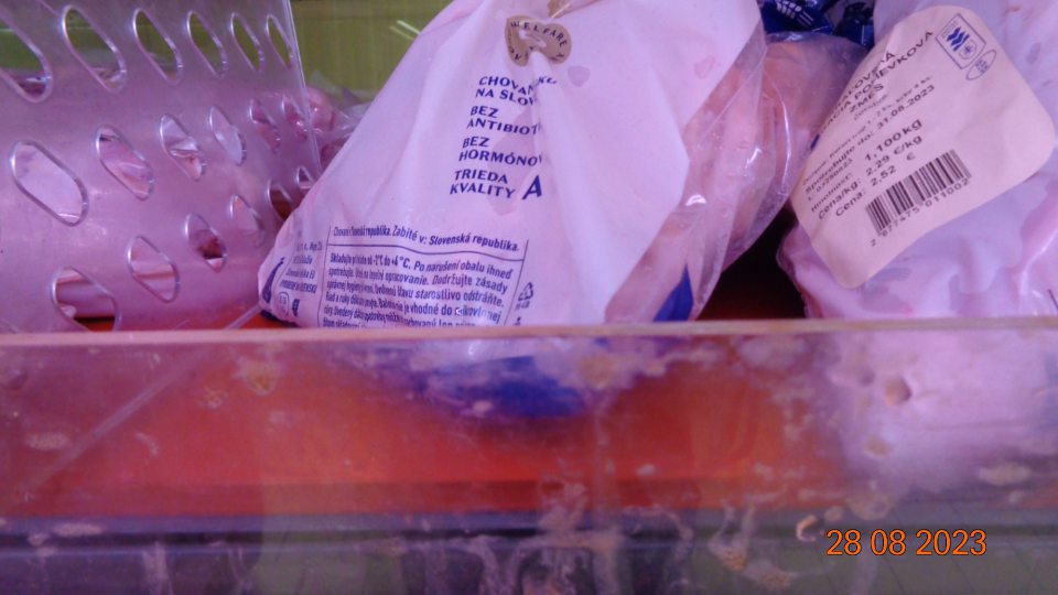 Znečistená chladiaca vitrína s uloženým hydinovým mäsom.