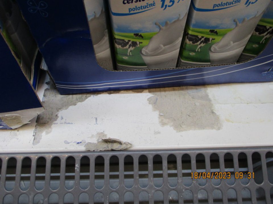 V chladiacom boxe znečistené police zvyškami obalového materiálu.