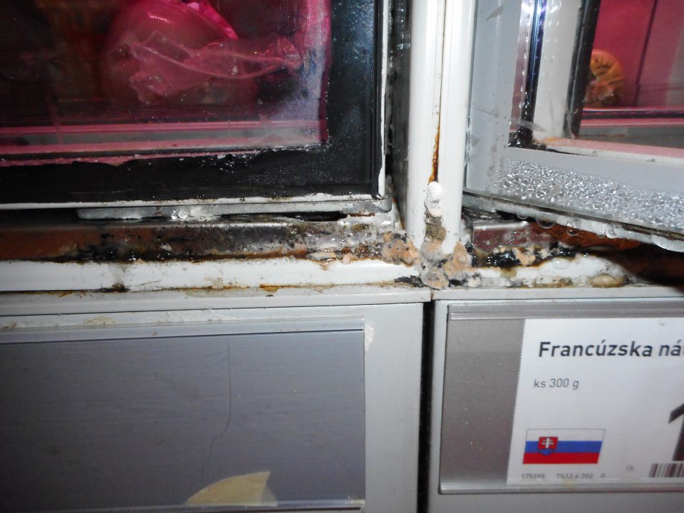 Kondenz a nečistoty na spodnej časti dvierok chladiacej vitríny mäsa a mäsových výrobkov na predajnej ploche.