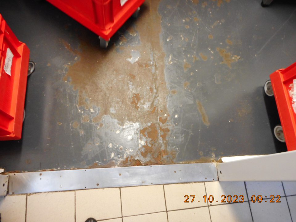 Hrdzavá podlaha a odlupujúci sa náter podlahy v chladiacom boxe určenom pre mäsové výrobky.