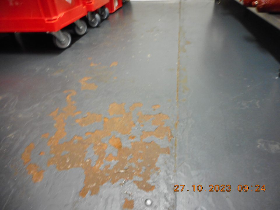 Hrdzavá podlaha a odlupujúci sa náter podlahy v chladiacom boxe určenom pre údeniny.