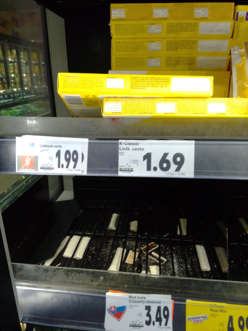 Znečistená polica mraziacej vitríny so zvyškami rozsypaných potravín.