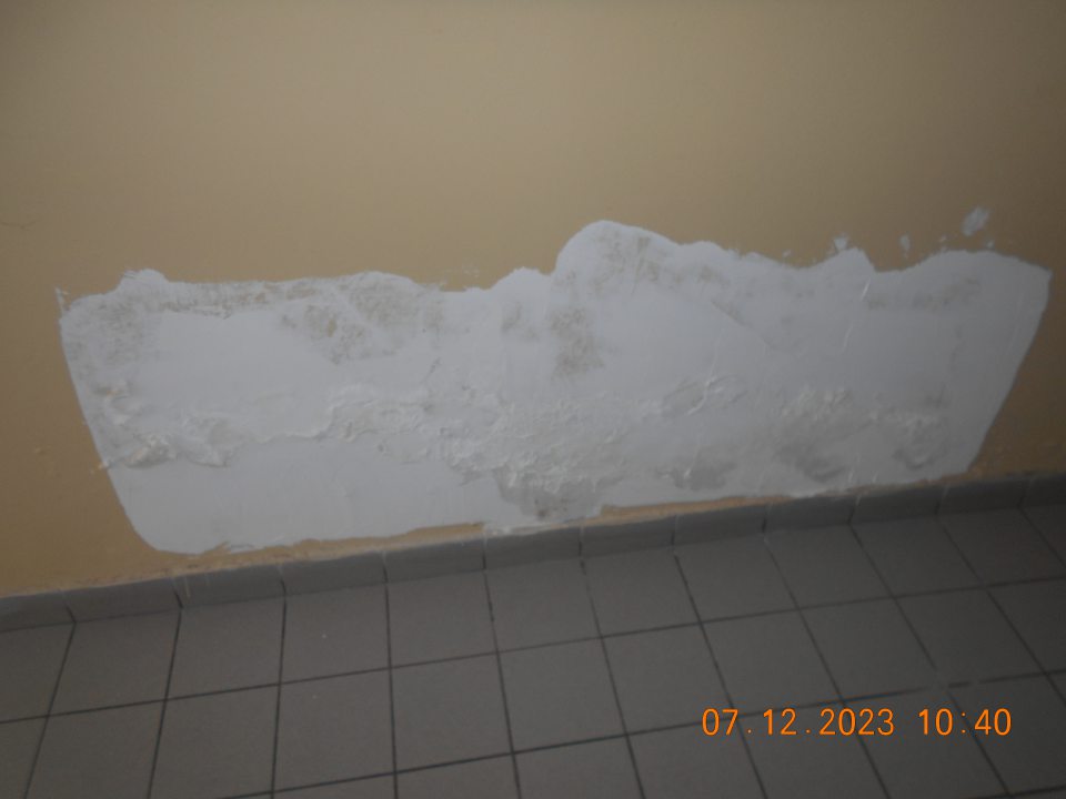 poškodený olúpaný náter steny na spojovacej chodbe pri Šatniach zamestnancov