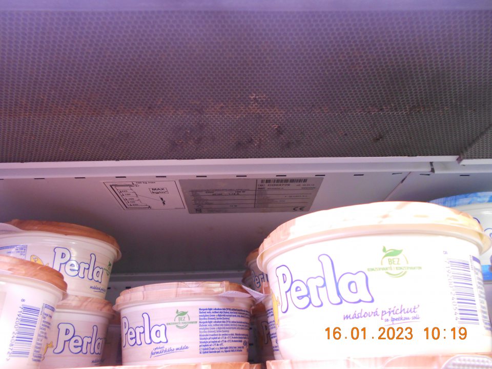 Zistená znečistená vrchná časť chladiarenskej vitríny s uchovávanými mliečnymi výrobkami v ťažko dostupných miestach ( kovová mriežka).