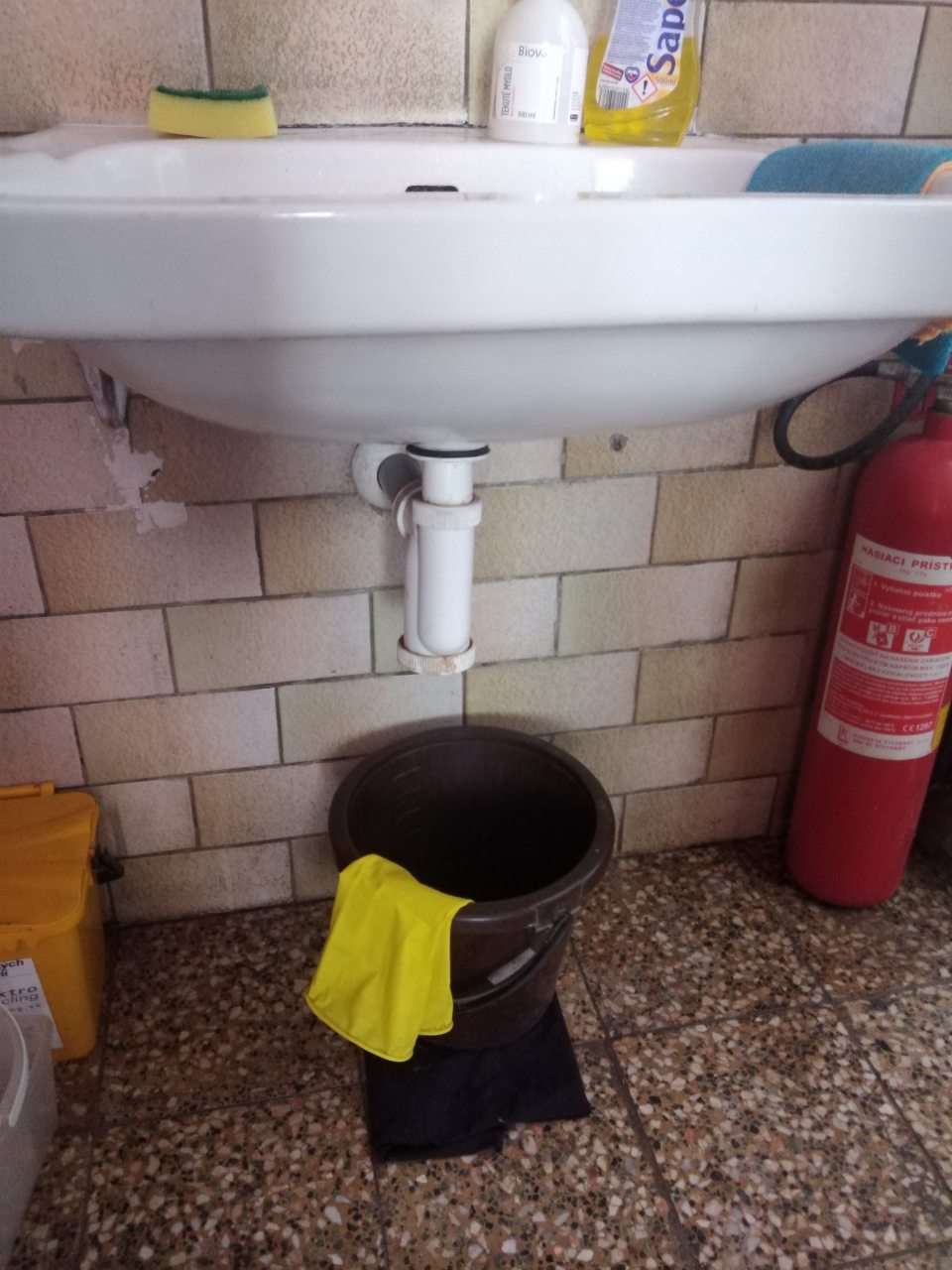 Poškodená podlaha a steny v priestoroch príjmu tovaru. - Poškodené a tečúce umývadlo v sklade. 