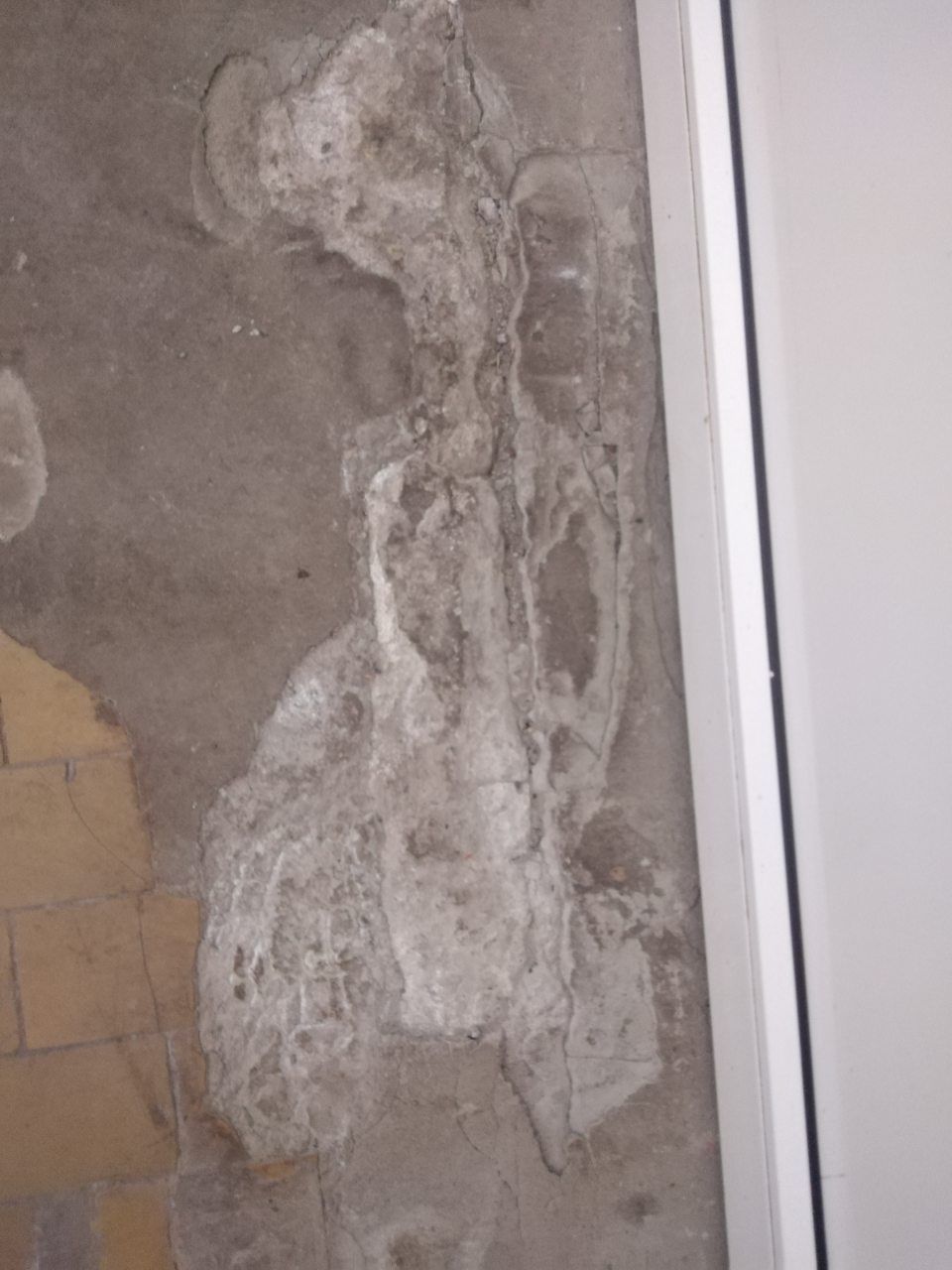 Poškodená podlaha a steny v priestoroch príjmu tovaru. 