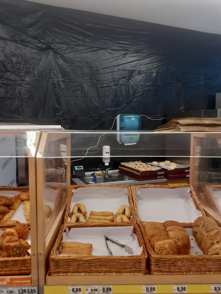 Dopek vykonávaný počas rekonštrukčných stavebných prác v zázemí vedľa stena, zakrytej tmavou fóliou.