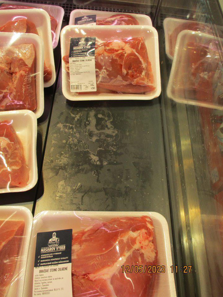 Znečistený chladiaci pult s mäsovými výrobkami. 