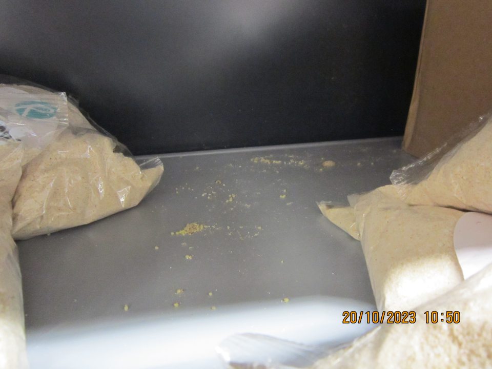 Vývojové štádia mole potravinovej (zámotky) na regáli, kde je uložený tovar „Ciroková kaša instantná“ 200g.