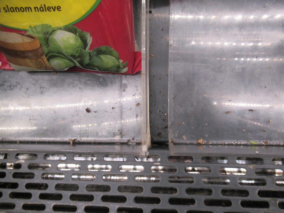 Znečistenie regálov chladiacej vitríny slúžiacej na uchovávanie spracovanej zeleniny, ovocia obsahom výrobkov a mechanickými nečistotami.