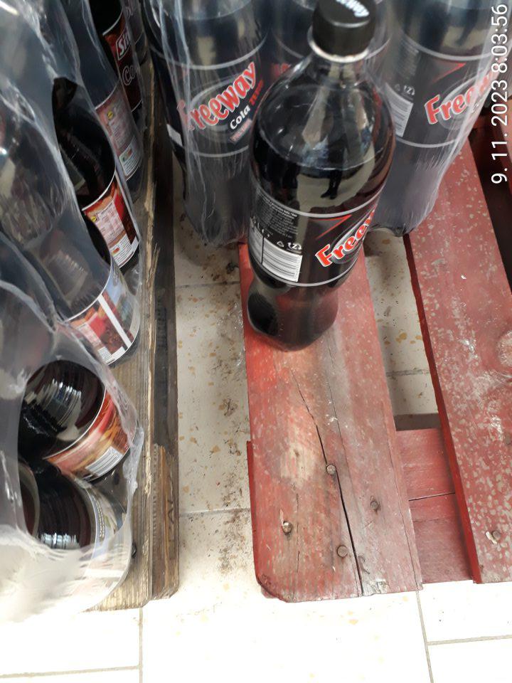 Predajná plocha: priestor pri balených vodách znečistený mechanickými nečistotami a hrubou vrstvou prachu.