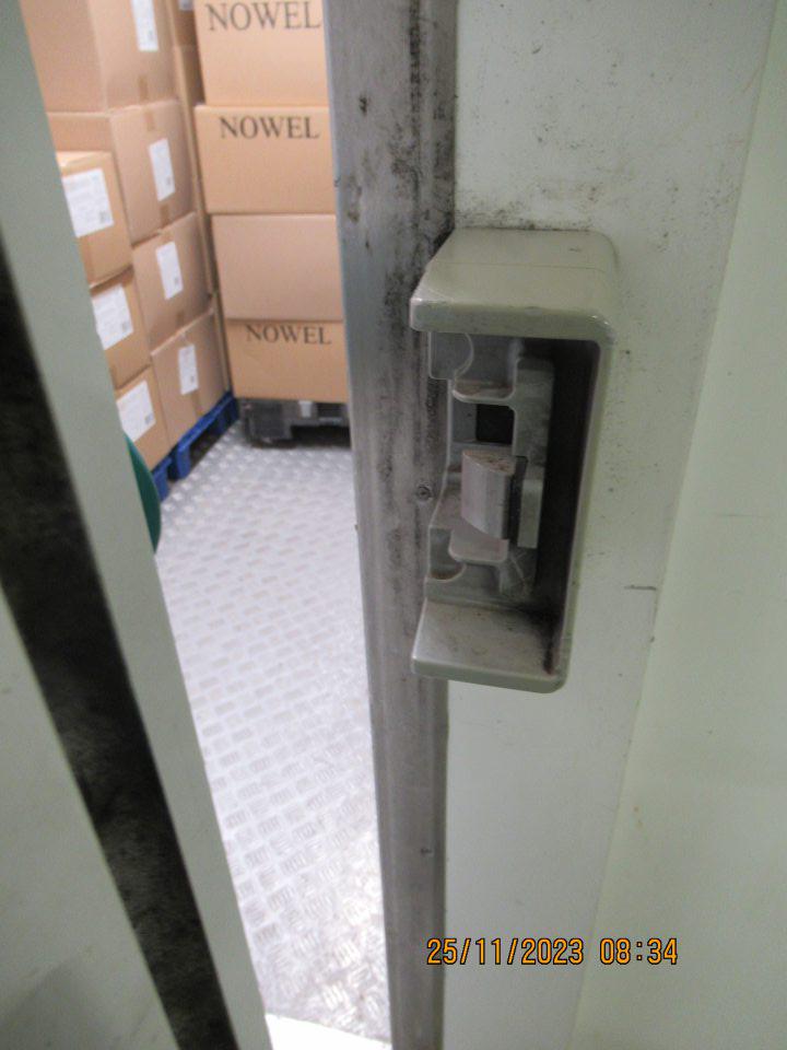 Nevyhovujúci hygienický stav tesniacej gumy na dverách do mraziaceho a chladiaceho zariadenia v zázemí - znečistenie čiernymi nečistotami pripomínajúcich pleseň.