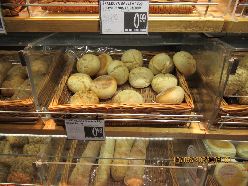 Chýbajúci kryt na regáli s pekárskymi výrobkami v predajni.