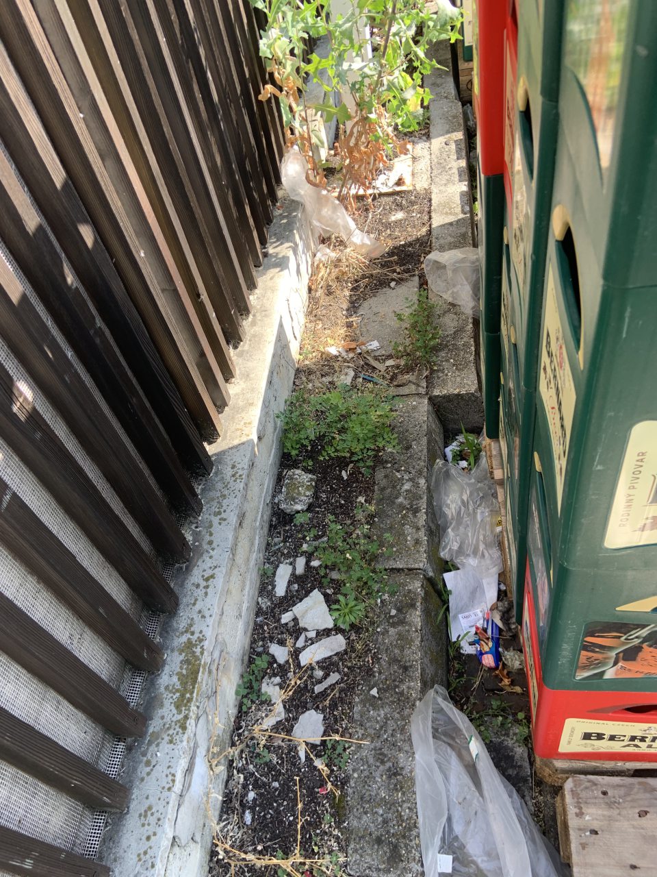 hromadenie odpadu v priestoroch mimo nádob na to vyčlenených: plastový odpad medzi paletami s prepravkami a plotom