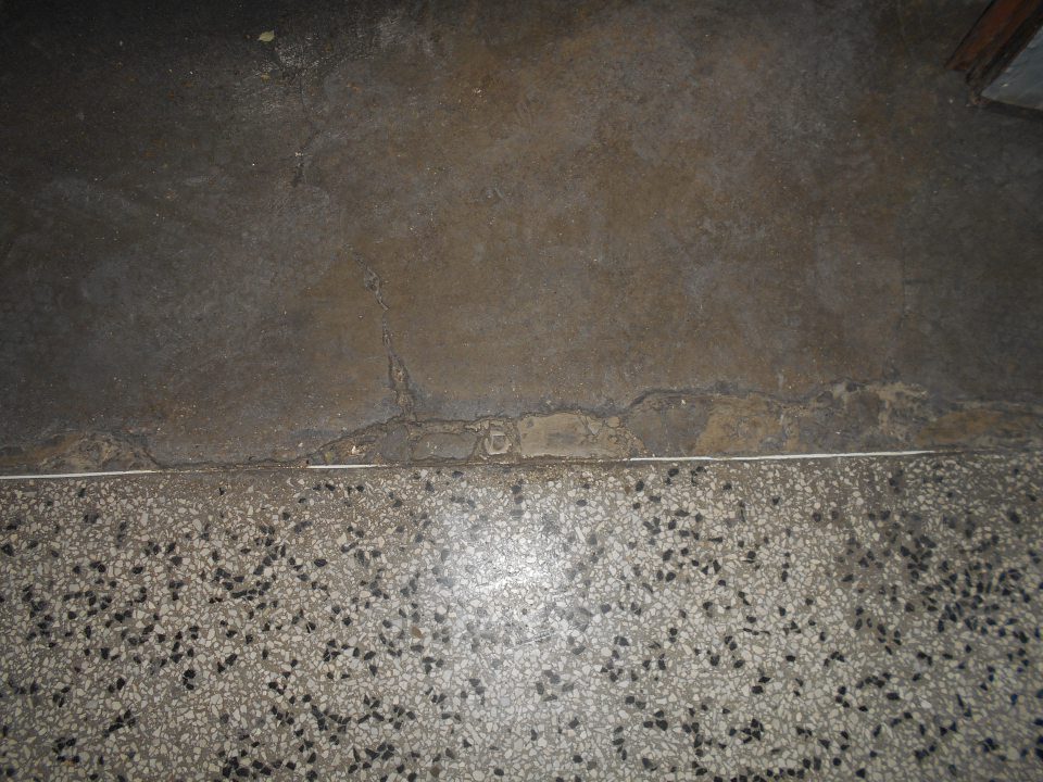 Lokálne narušená súvislosť podlahy v zázemí predajne.