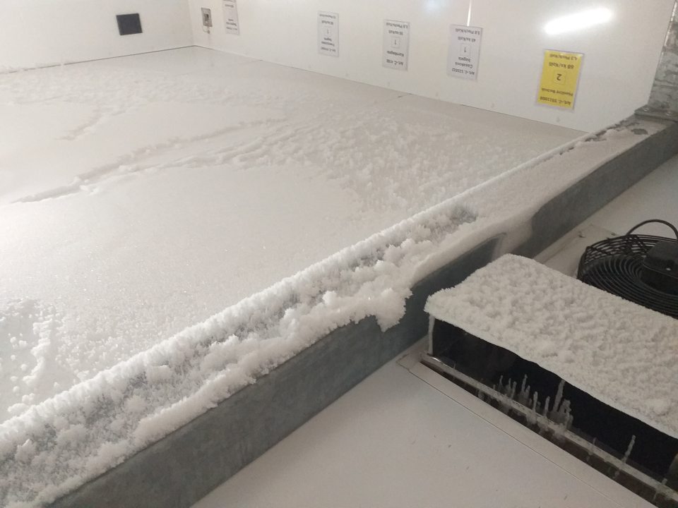 Nadmerná námraza na chladiacej jednotke a strope v mraziacom boxe na uchovávanie mrazených pekárskych polotovarov.