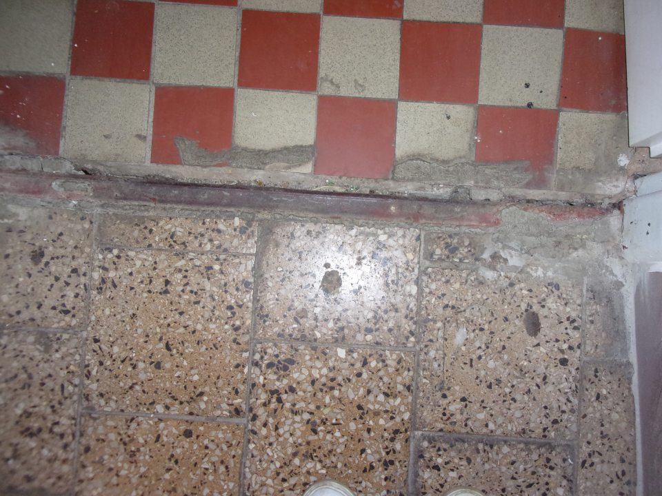 Poškodený prah na prechode zo skladu.