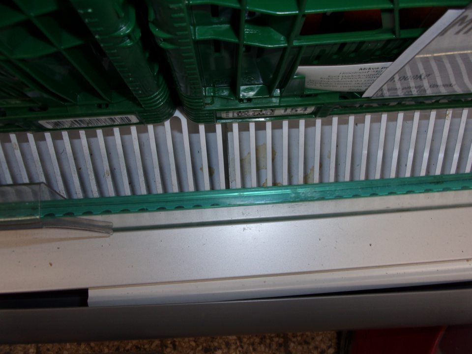 Zatečený a znečistený priestor pod mriežkami v chladiacom zariadení na zeleninu.