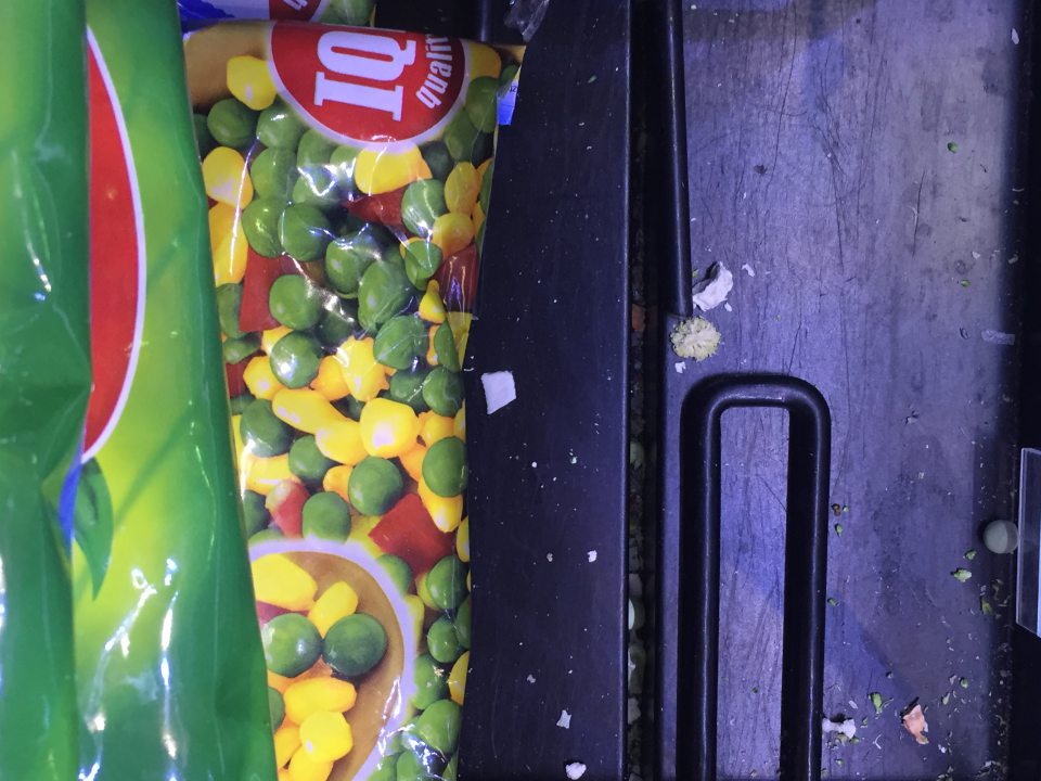 Úložná plocha mraziaceho zariadenia  na vystavovanie a predaj  hlbokozmrazenej zeleniny  znečistená prachom,  špinou  a zvyškami predávaného tovaru.