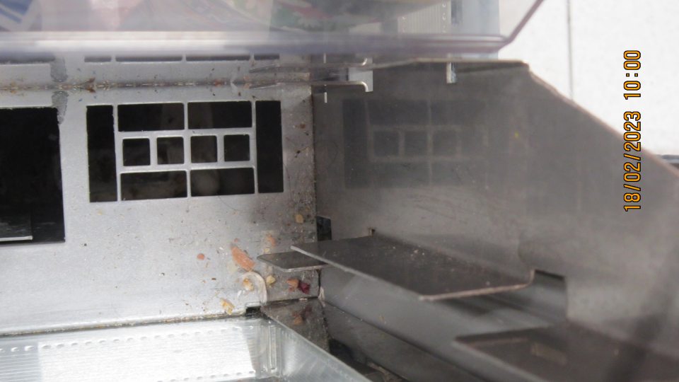 Na predajnej ploche v časti predaja mliečnych výrobkov v otvorenom chladiacom zariadení znečistený priestor pod mriežkou a kovová konštrukcia mriežky prachom, zaschnutou špinou a napadanými nečistotami.