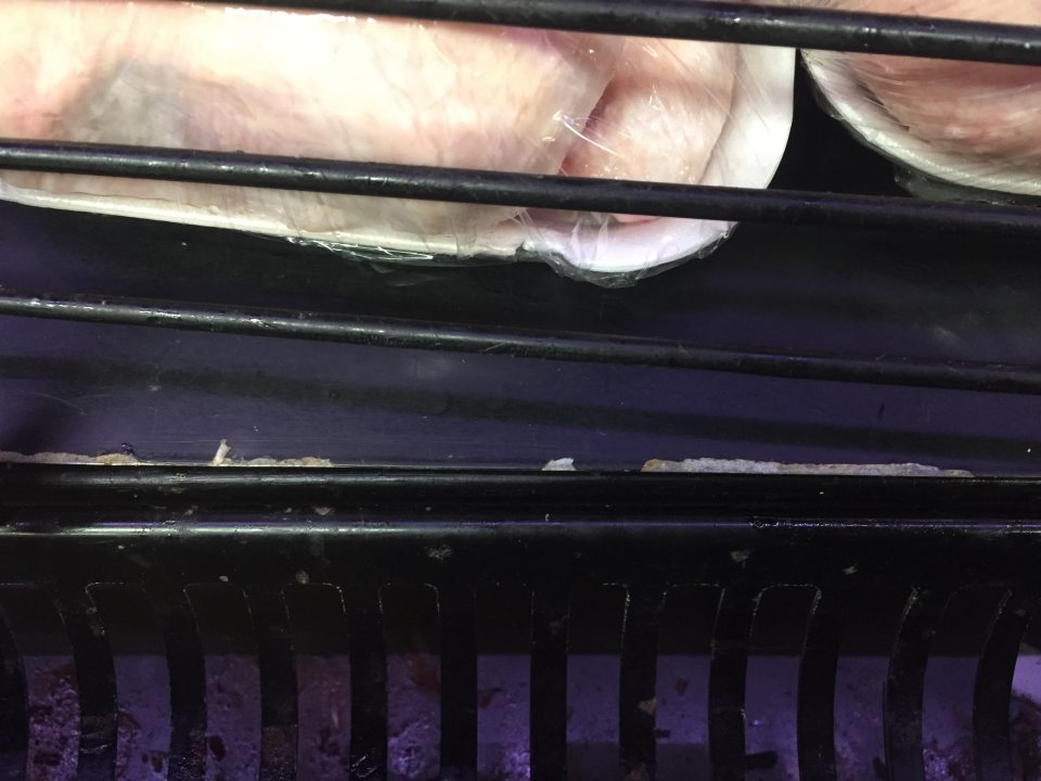  Priestor pod mriežkou v chladiacom zariadení pre  chladenú hydinu  je znečistený zaschnutou tekutinou a špinou.