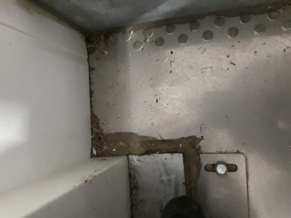 Silne znečistená podlaha pri vstupe do chladiaceho boxu na skladovanie mliečnych výrobkov.