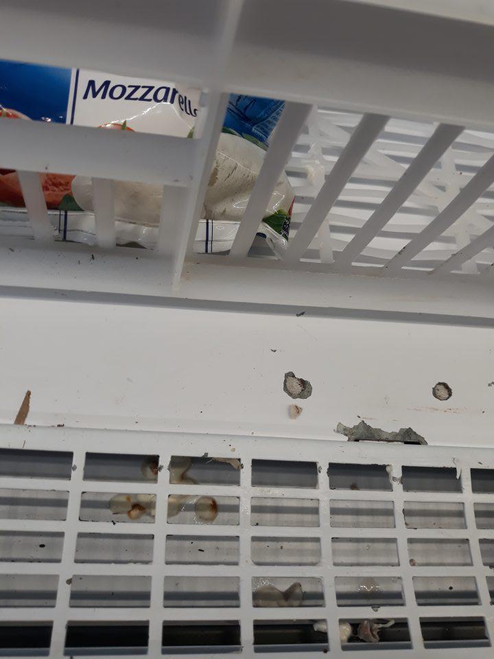 Na predajnej ploche mriežka a priestor pod mriežkou v chladiacom zariadení s umiestnenými mliečnymi výrobkami /Mozzarelou, Smotanová nátierka, Pudingami Fantasia/ znečistené zaschnutými zvyškami z potravín, napadanými nečistotami.