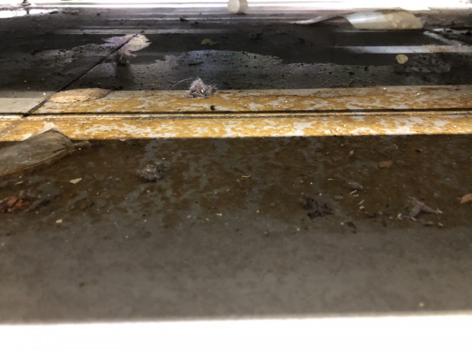 Znečistená podlaha pod regálom so sirupmi a džúsmi.